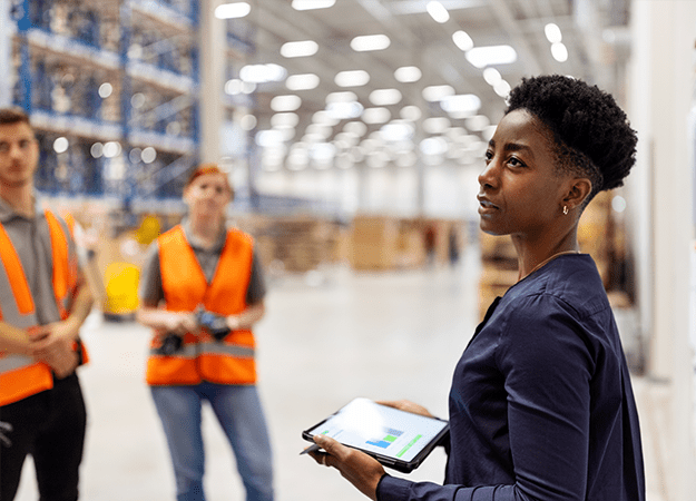 Professional in warehouse holding tablet