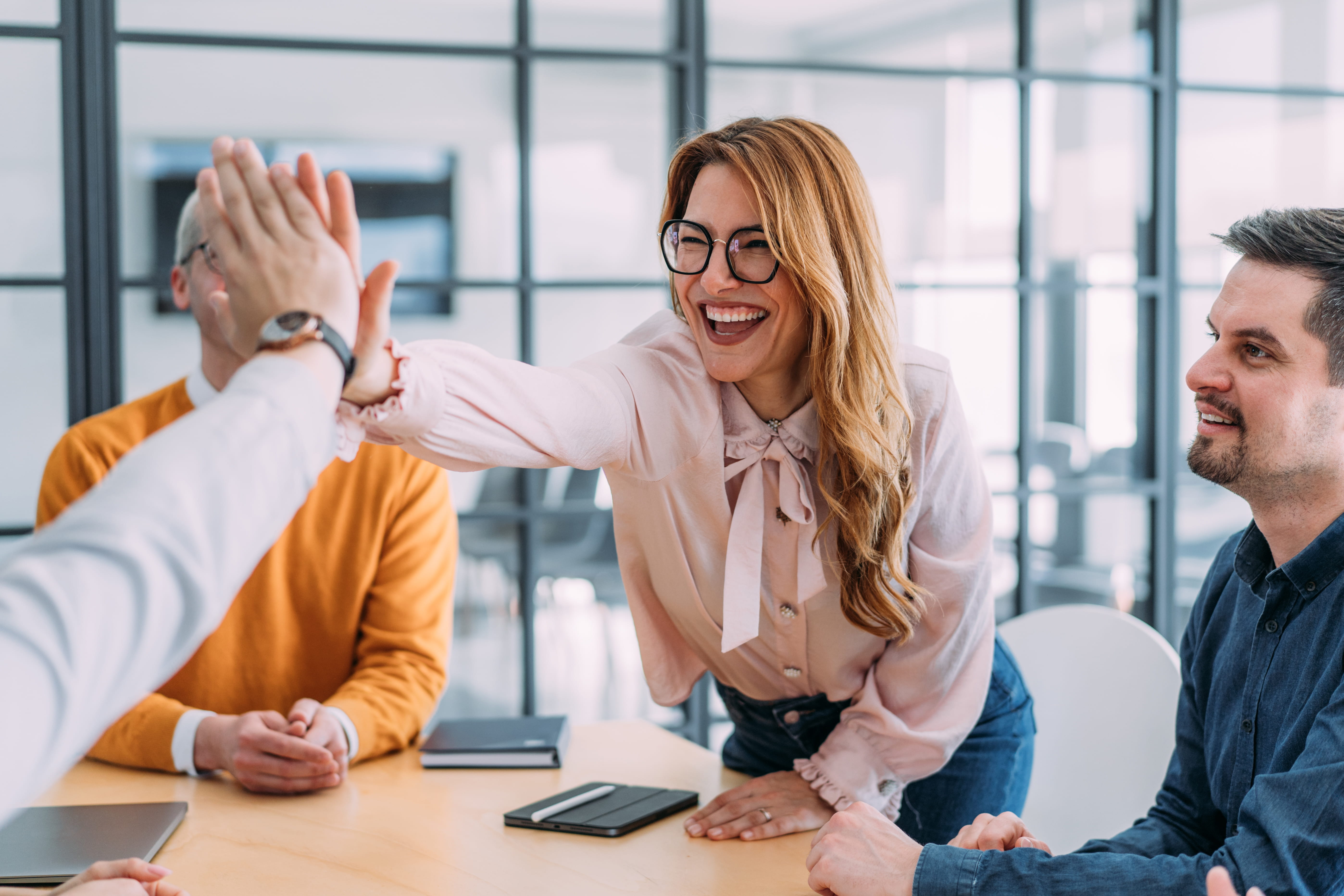 Cheerful businesspeople giving high five to each other