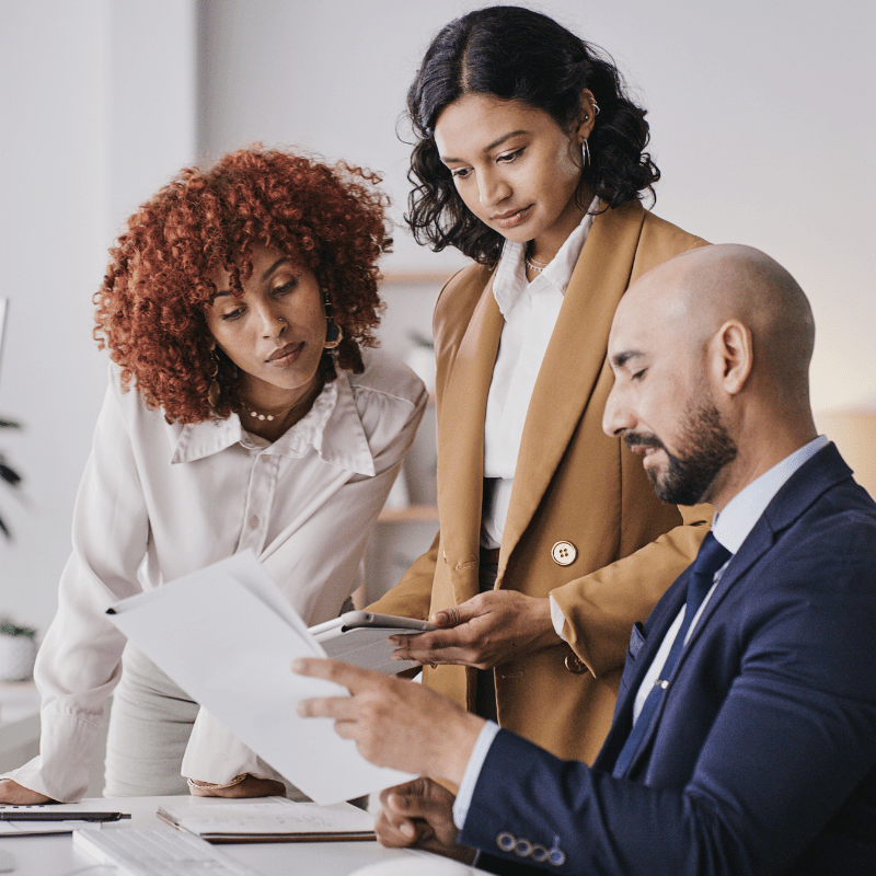 three people looking at a report